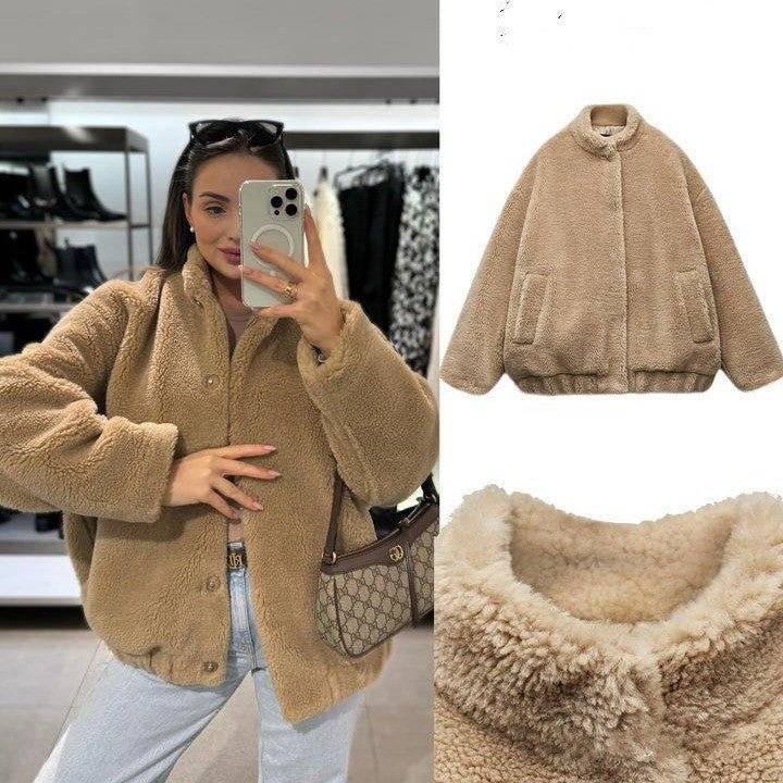 A woman wearing a beige fleece bomber jacket with long sleeves, round neckline, and front pockets. The jacket appears to be made of chenille fabric.